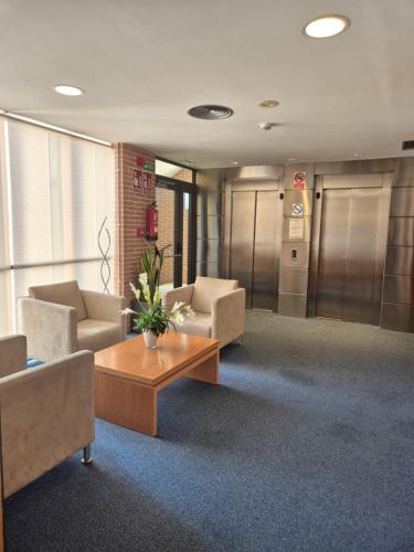 a lobby with couches and a table in a building at Hotel Reston Valdemoro in Valdemoro