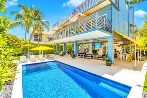 an exterior view of a house with a swimming pool at Waterfront Covered alfresco lounge Heated Pool Anchor Key in Islamorada