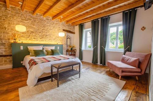 a bedroom with a bed and a chair at Le clos de la ferme 