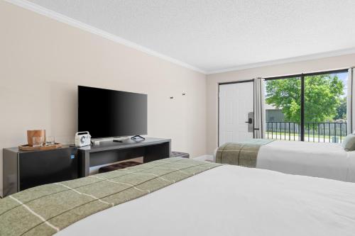 a hotel room with two beds and a flat screen tv at Branson Falls Lodge in Branson