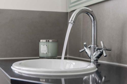 Un lavabo blanco con grifo en un baño. en "Villa Minerva" Ferienwohnung 09, en Kühlungsborn