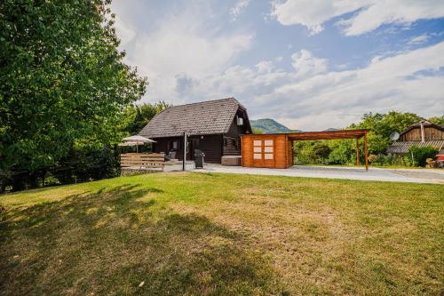 a small wooden building with a pavilion in a yard at Log Cabin Vista View with Seasonal Hot Tub in Bizeljsko