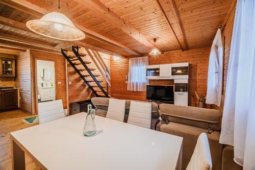a dining room and kitchen with a white table and chairs at Log Cabin Vista View with Seasonal Hot Tub in Bizeljsko
