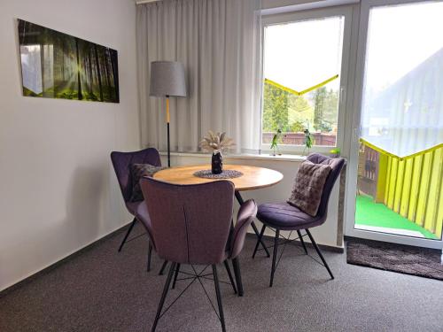 a dining room with a table and chairs and a window at Ferienwohnung Martina in Hasselfelde