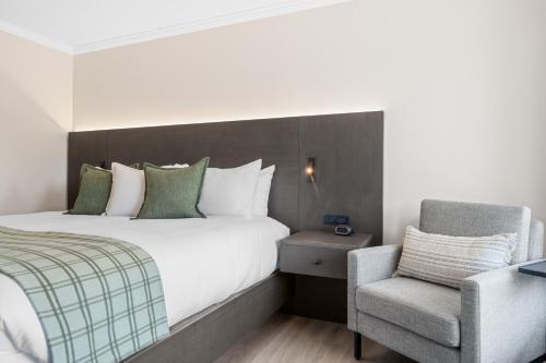 a hotel room with a bed and a chair at Branson Falls Lodge in Branson