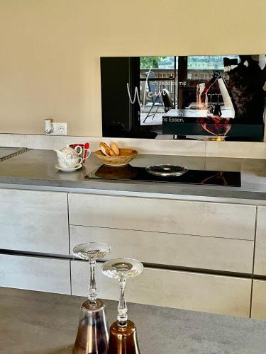 a kitchen with two wine glasses on a counter at Restaurant Appartements Almdiele in Hart im Zillertal