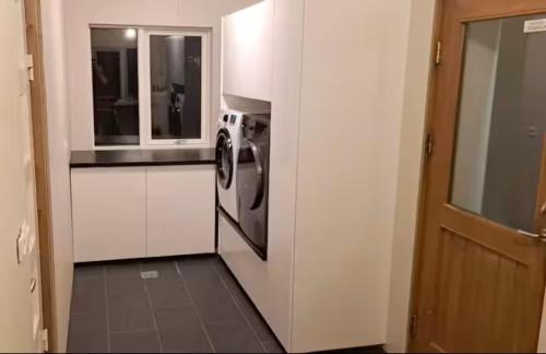 a kitchen with a microwave and a washer and dryer at The Old farm house in Iceland in Selfoss