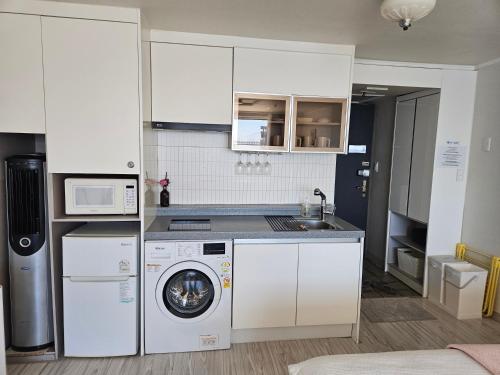 a kitchen with a washing machine and a washer at 에벤에셀 in Busan