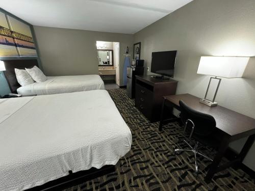 a hotel room with two beds and a desk with a computer at Homegate Inn And Suites in Collierville