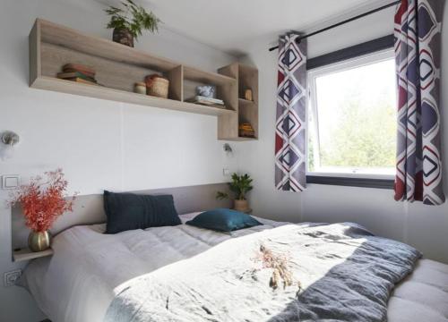 a bedroom with a large bed with a window at Camping Hourtin in Hourtin