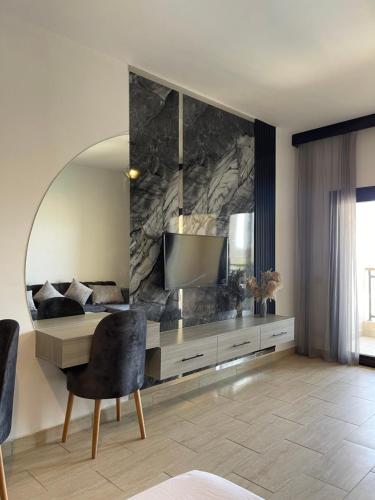 Una sala de estar con un televisor y una silla. en AlDau Heights Apartments, en Hurghada