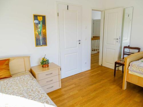 a bedroom with a bed and a dresser and a table at Reetdachhaus im Fischerdorf in Freest