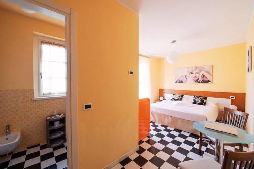 a bedroom with a bed and a bathroom with a sink at T'AMI Hotel Resort Spa in Selvino