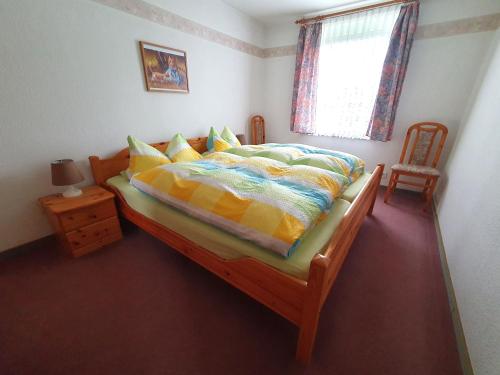 a bedroom with a bed and a window and a chair at Nelius - Ferienhaus 1 in Stiege