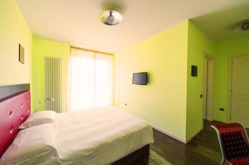 a bedroom with yellow and green walls and a bed at T'AMI Hotel Resort Spa in Selvino