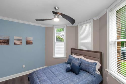 a bedroom with a blue bed with a ceiling fan at The Panola Mansion - Indoor Pool & Pavilion in Stockbridge