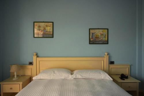 a bedroom with a bed with two pictures on the wall at T'AMI Hotel Resort Spa in Selvino