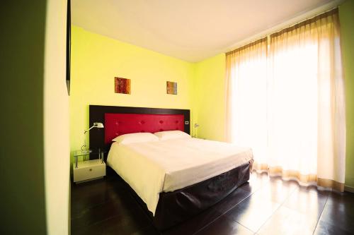 a bedroom with a large bed and a large window at T'AMI Hotel Resort Spa in Selvino