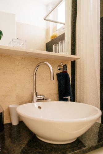 a white sink in a bathroom with a shower at Villeni Panorama Apartment Oktonia in Okhthonía