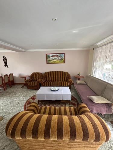 a living room with two couches and a table at Willa Rudno Nad Jeziorem Parter in Rudno