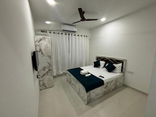 a bedroom with a bed with a ceiling fan at Atithi Homes Luxe Kandivali Suites in Mumbai