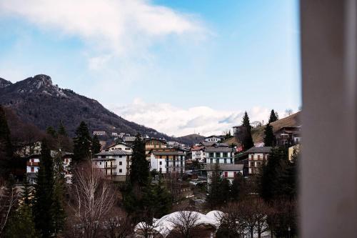 a city with buildings and a mountain in the background at T'AMI Hotel Resort Spa in Selvino