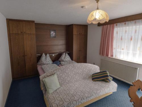 a bedroom with a bed and a chandelier at Haus Hahnenkamm in Nesselwängle