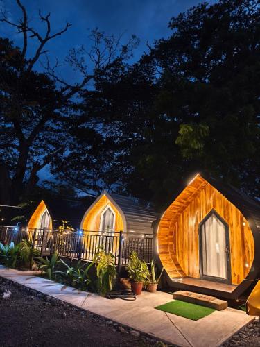 a home with a wooden house with lights on it at Rincón del Mar Glamping in Potrero