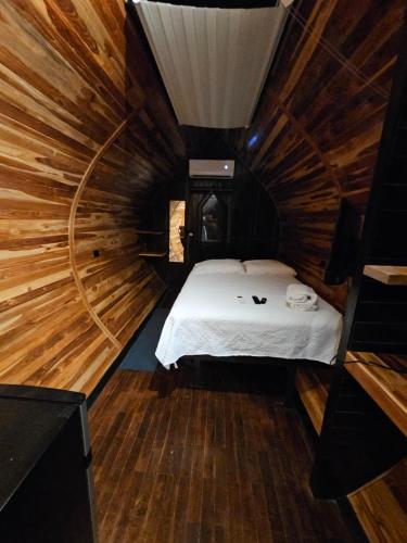 a room with a bed in a wooden cabin at Rincón del Mar Glamping in Potrero