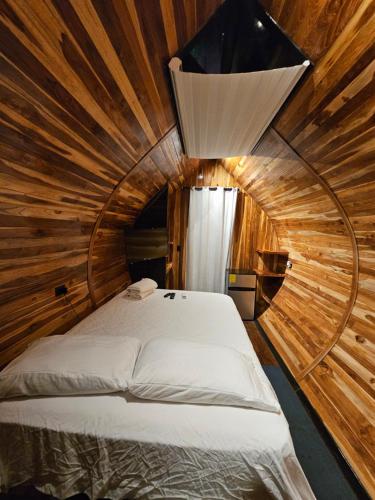 a bedroom with a bed in a wooden room at Rincón del Mar Glamping in Potrero