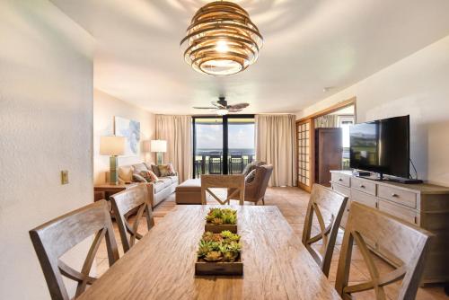 Un comedor con mesa y sillas y una sala de estar. en The Turquoise Turtle- AC-Pool-Ocean View, en Koloa