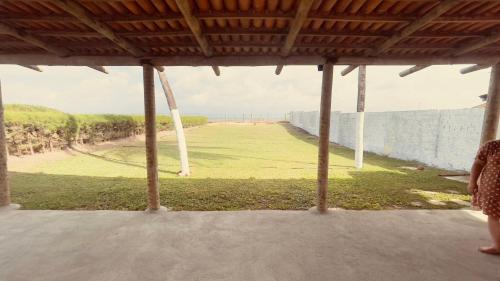 a woman standing on a porch looking out at a field at Casa de Veraneio na Praia in Extremóz