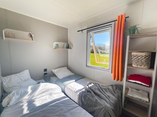 a small room with two beds and a window at Camping Tamniès in Tamniès
