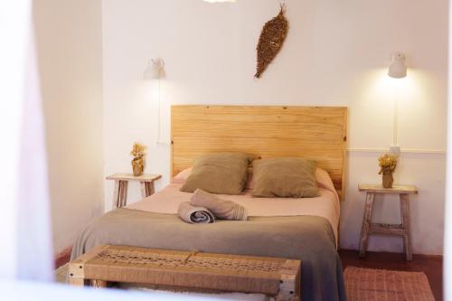 a bedroom with a large bed with a wooden headboard at Mestiza Hostal in Humahuaca