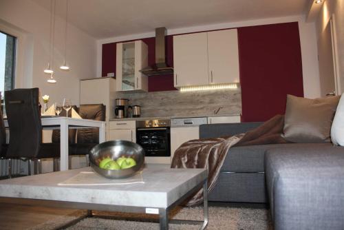 a living room with a couch and a bowl of fruit on a table at 4 Sterne Ferienwohnung Schlossblick Sauna Pool Whirlpool pri in Braunfels