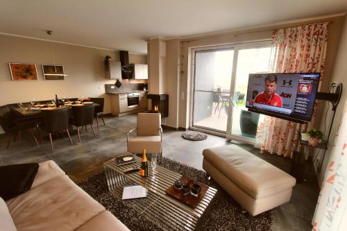 a living room with a couch and a large screen television at Ferien_VILLA EASY LIVING in Göhren-Lebbin