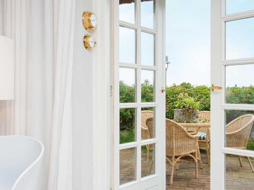 an open door to a patio with a table and chairs at Käpt'n Cook 4 von Appartements & Mehr in Kampen