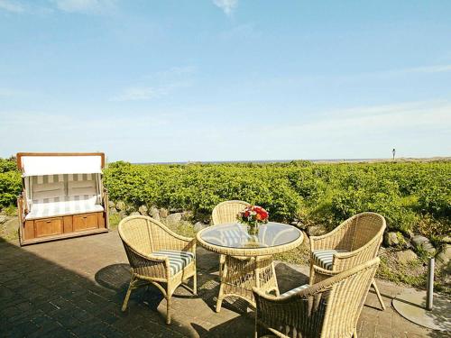 a patio with a table and chairs with a view of the ocean at Käpt'n Cook 4 von Appartements & Mehr in Kampen