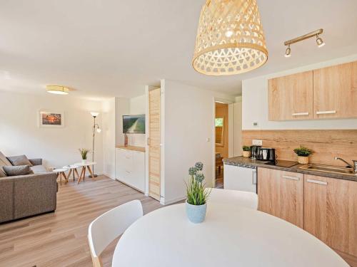 Una cocina y una sala de estar con una mesa blanca en una habitación. en Naturcampingplatz " Am Strand " Ostseebad Ückeritz, en Ückeritz