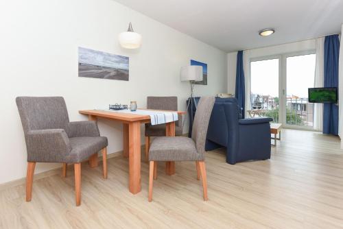 a living room with a table and chairs and a couch at Haus Hafenblick in Bensersiel