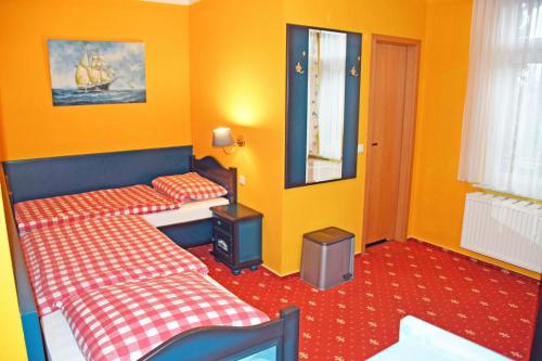 two beds in a room with yellow walls at Appartementhaus auf Moenchgut in Thiessow