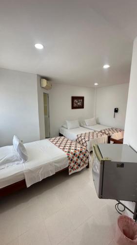 バランカベルメハにあるHotel Olga Luciaのベッド2台とテレビがあるホテルの部屋