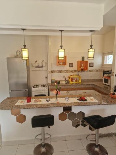 a kitchen with a counter and two bar stools at Apartment 3 in Tangier