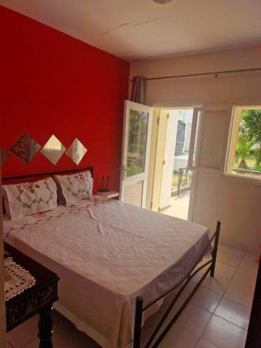 a bedroom with a bed with a red wall at Apartment 3 in Tangier