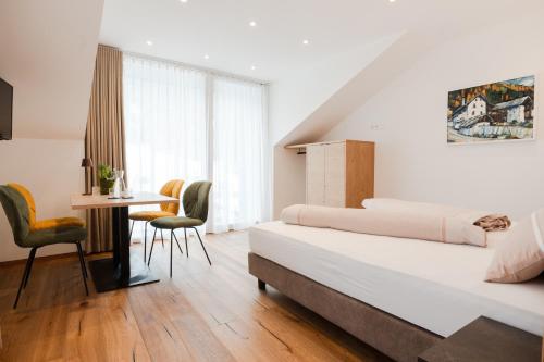 a bedroom with a bed and a table and chairs at Residence Katrin in San Valentino alla Muta