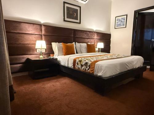 a bedroom with a large bed with a wooden headboard at Hotel Grand Arcasia Saket- Near PVR Anupam in New Delhi