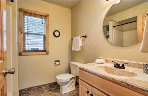 a bathroom with a sink and a toilet and a mirror at 5 Miles from Mt- Rushmore with private hot tub in Keystone