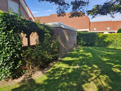 カロリーネンジールにあるNr 100 - Ferienhaus Uferglückの塀とレンガ造りの庭