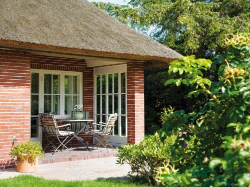 a brick house with a table and chairs on a patio at Min Go von Appartements & Mehr in Kampen