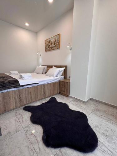 a bedroom with a bed and a black rug on the floor at Blue Horizon in Batumi
